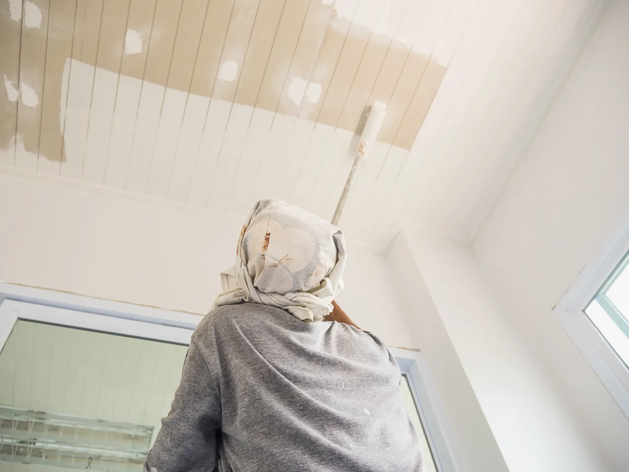Ceiling painting with a roller. Illustrative stock photo.