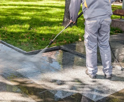 Pressure washing a paved driveway at a residential property.